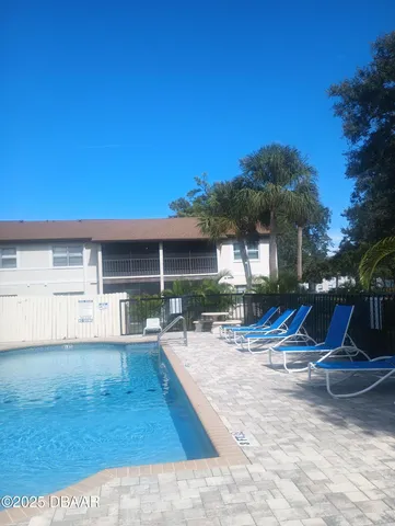 a view of a house with backyard and sitting area