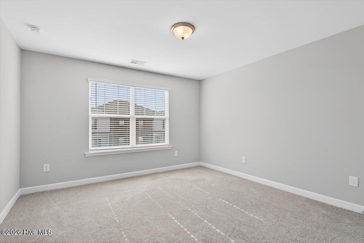 8840 Radcliff Drive Northwest Calabash, NC 28467 - Photo 36 of 54 Secondary bedroom with great natural light and a versatile layout for guests or office space.