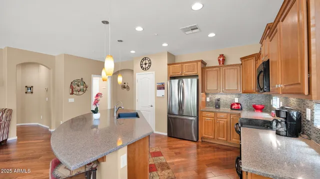 a kitchen with stainless steel appliances granite countertop a refrigerator a oven and a sink