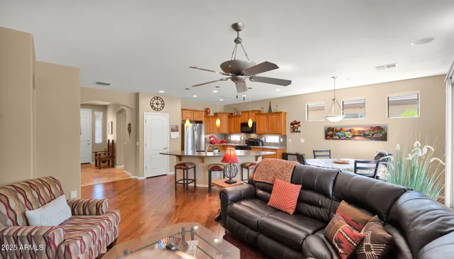 a living room with furniture kitchen view and a chandelier