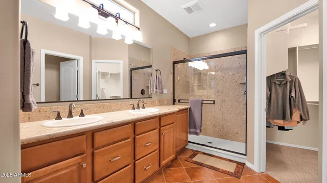 a bathroom with a double vanity sink a mirror and shower