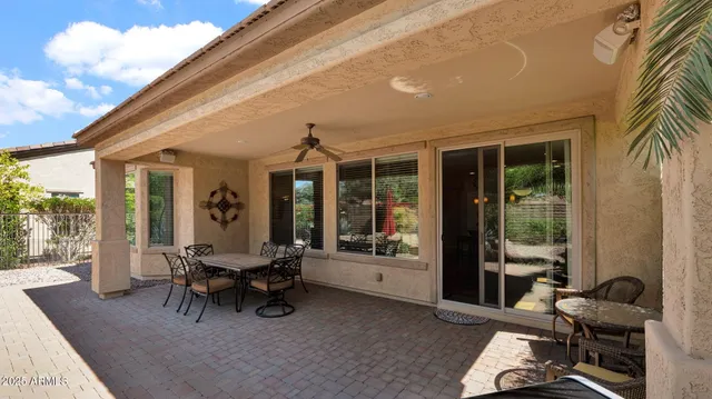 a view of a patio with table and chairs and floor to ceiling window