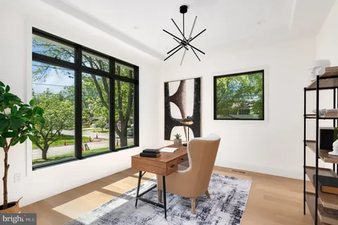 a dining room with furniture floor to ceiling windows and garden view