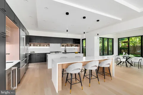 a large white kitchen with a table and chairs