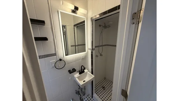a bathroom with a shower and a mirror