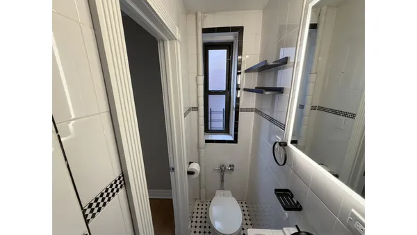a bathroom with a sink and mirror with bathtub