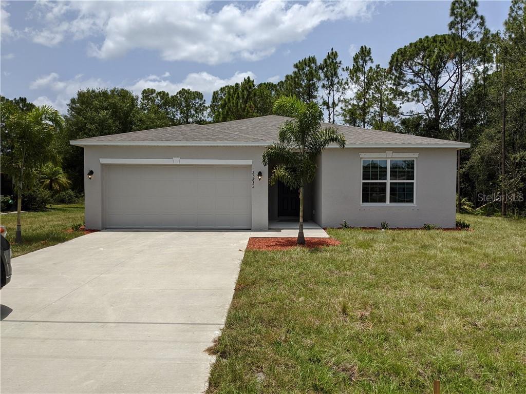 front view of a house with a yard and potted plants