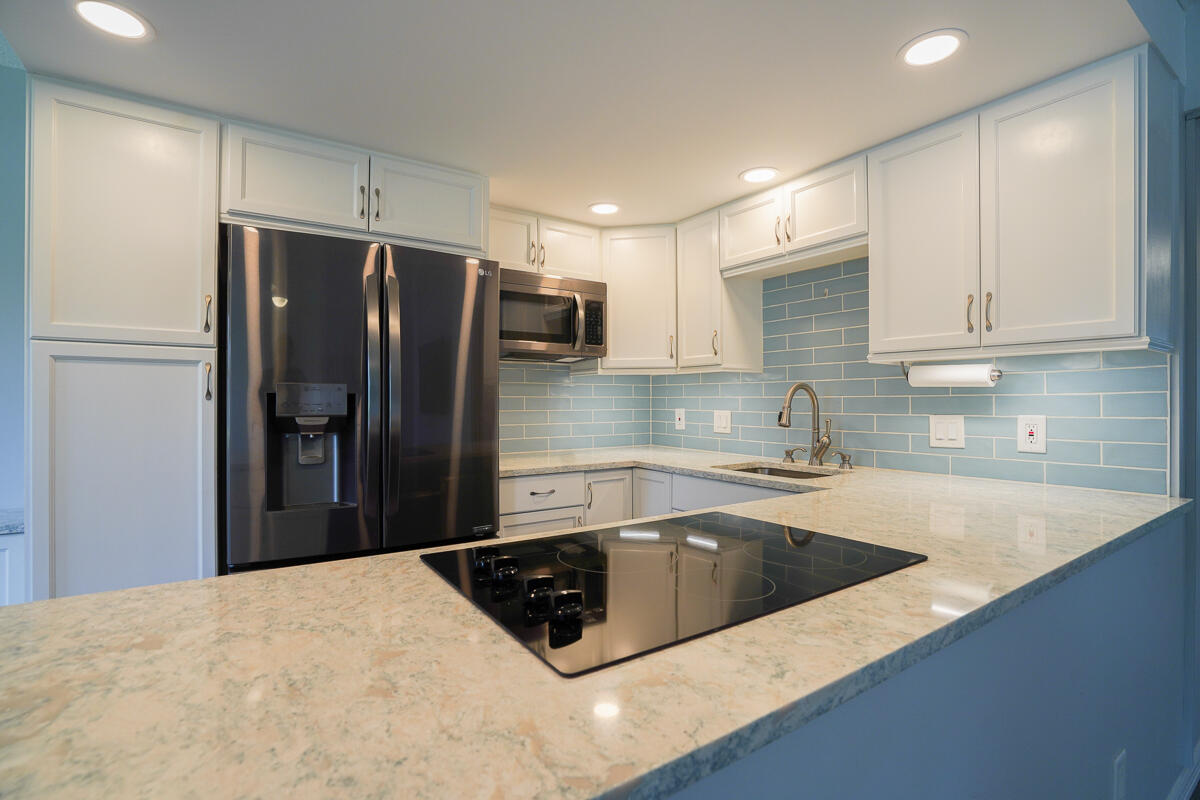 a kitchen with stainless steel appliances granite countertop a sink a refrigerator and a sink