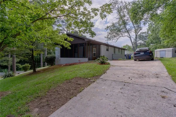 a front view of a house with a yard and a tree