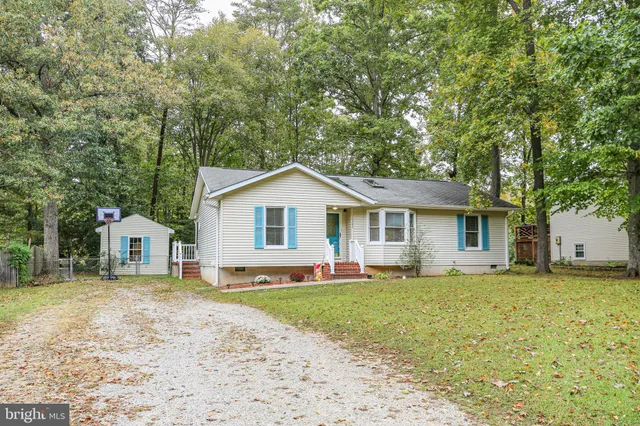 a front view of a house with a yard and trees