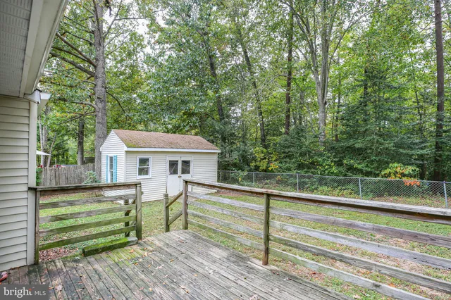 a view of a house with a yard chairs and wooden fence