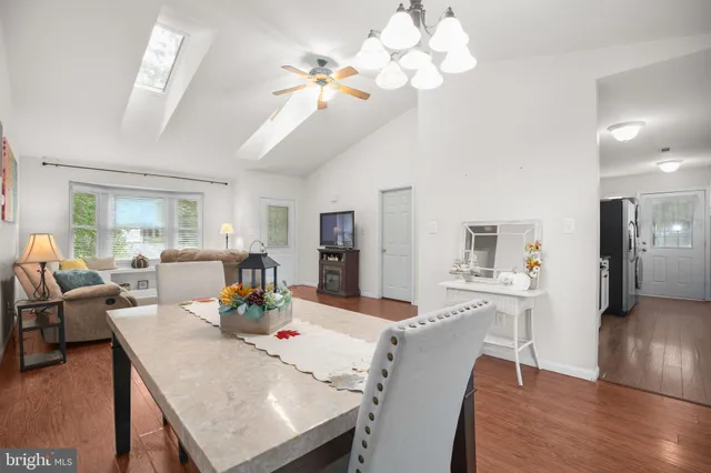 a view of a dining room with furniture a chandelier and wooden floor