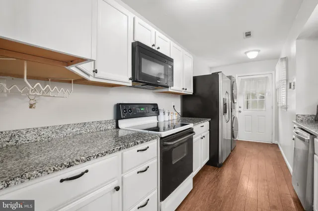 a kitchen with stainless steel appliances granite countertop a refrigerator stove and sink