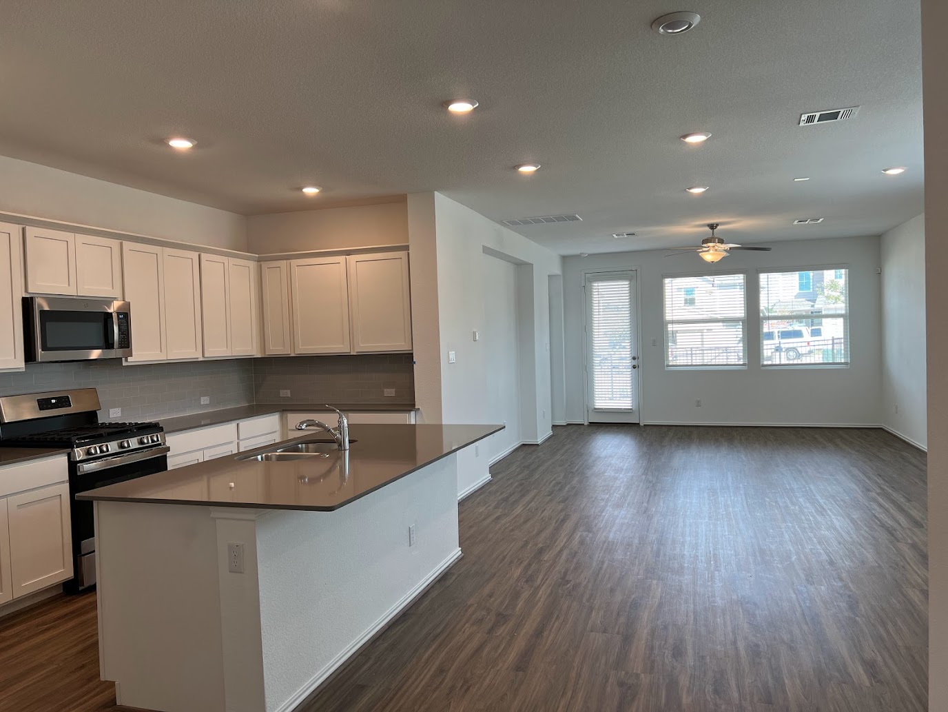 313 Montauk Loop Georgetown, TX 78628 - Photo 25 of 25 a kitchen with granite countertop a stove a sink a refrigerator and cabinets with wooden floor