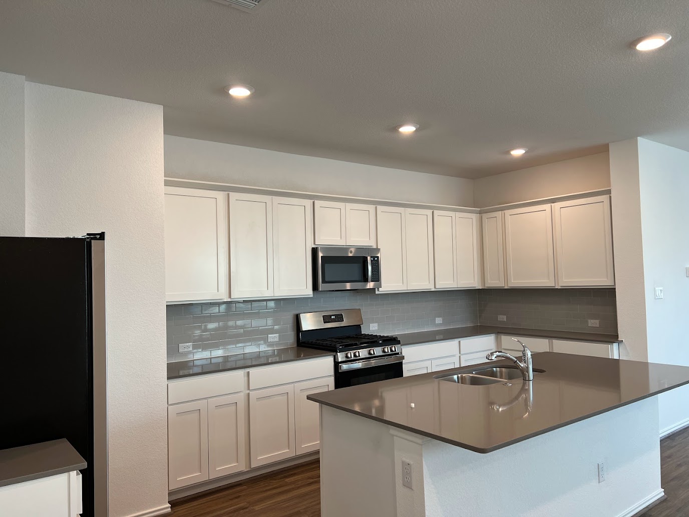 313 Montauk Loop Georgetown, TX 78628 - Photo 3 of 25 a kitchen with granite countertop a sink a stove a refrigerator and cabinets