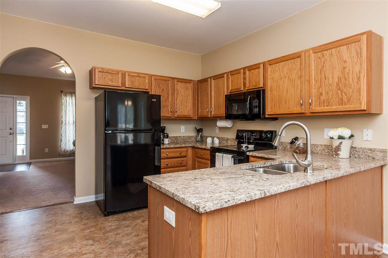 5421 Neuse Forest Road Raleigh, NC 27616 - Photo 9 of 21 a kitchen with granite countertop a refrigerator a stove and a sink