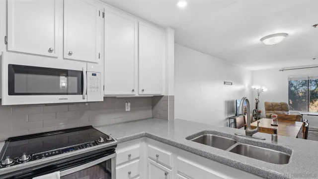 a kitchen with white cabinets a sink and a stove
