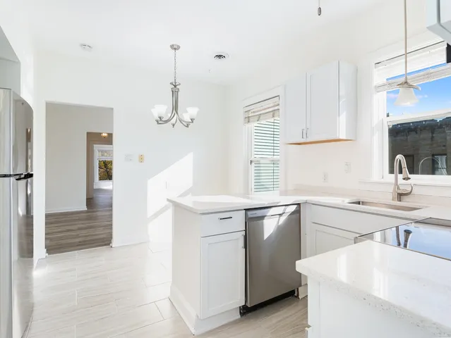a kitchen that has a sink a stove and a wooden floor