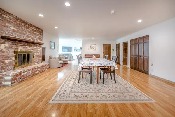 a living room with furniture and kitchen view with wooden floor