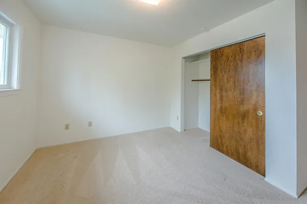 a view of an empty room with cabinet and mirrors