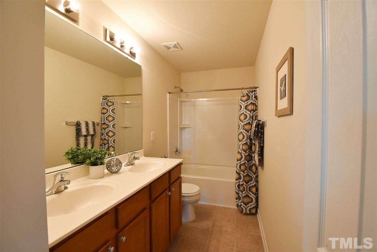4201 Kellett Lane Raleigh, NC 27616 - Photo 23 of 30 The add'l Bedrooms share the lg Hall Bath w/double sinks, neutral vinyl floor & tub-shower.