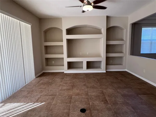 a view of an empty room with a cabinet and a window