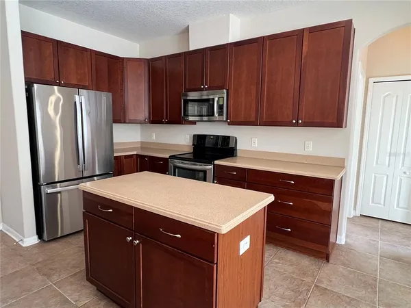 a kitchen with a refrigerator and a stove top oven