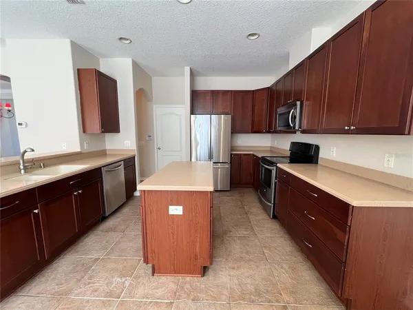a kitchen with stainless steel appliances granite countertop a stove a sink dishwasher and a refrigerator