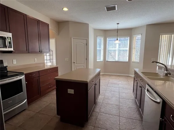 a kitchen with a stove sink and cabinets