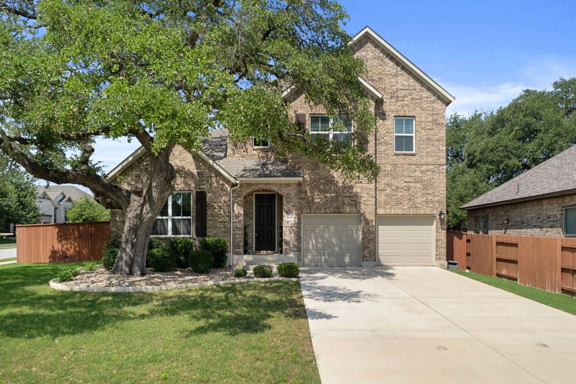 a front view of a house with a garden and tree