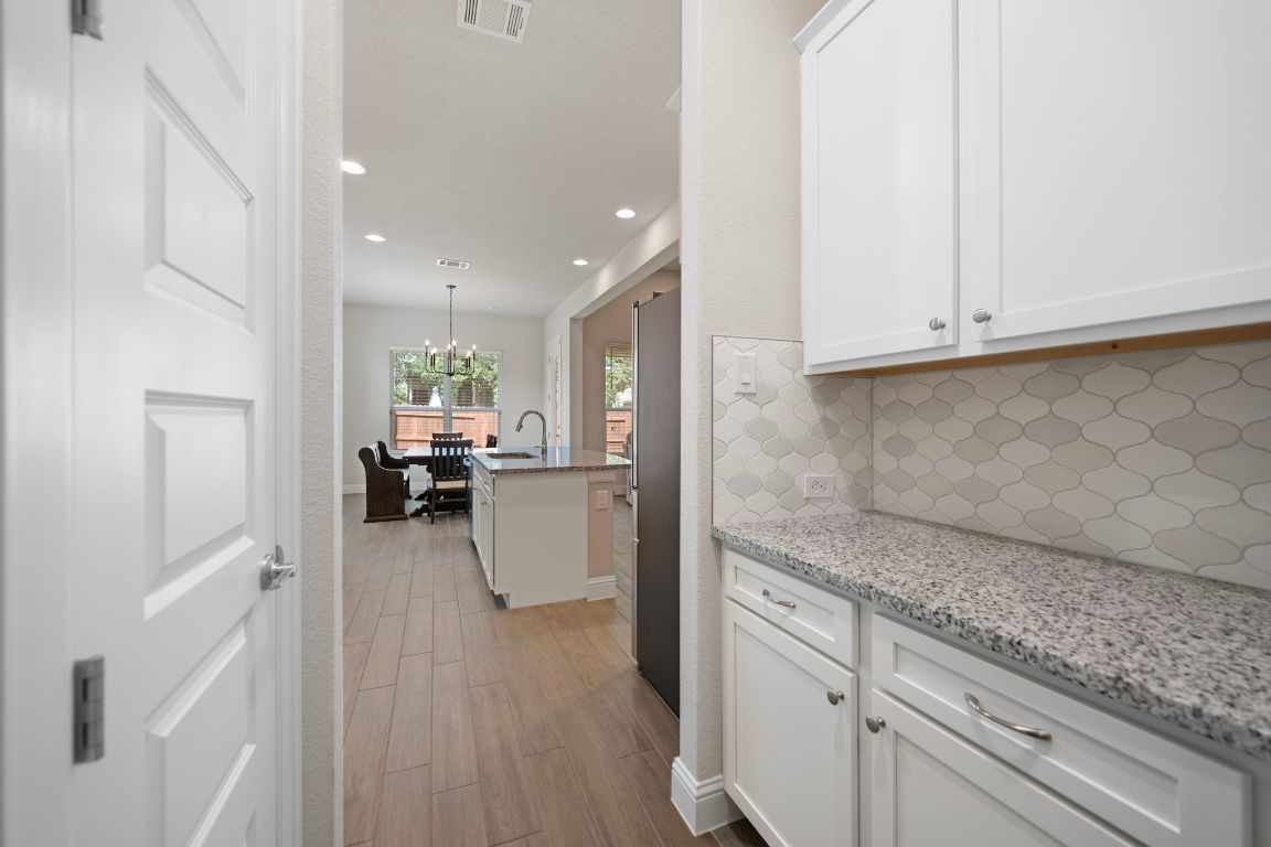 1601 Highland Ridge Road Georgetown, TX 78628 - Photo 13 of 37 a view of a kitchen with kitchen island a sink wooden floor and living room view