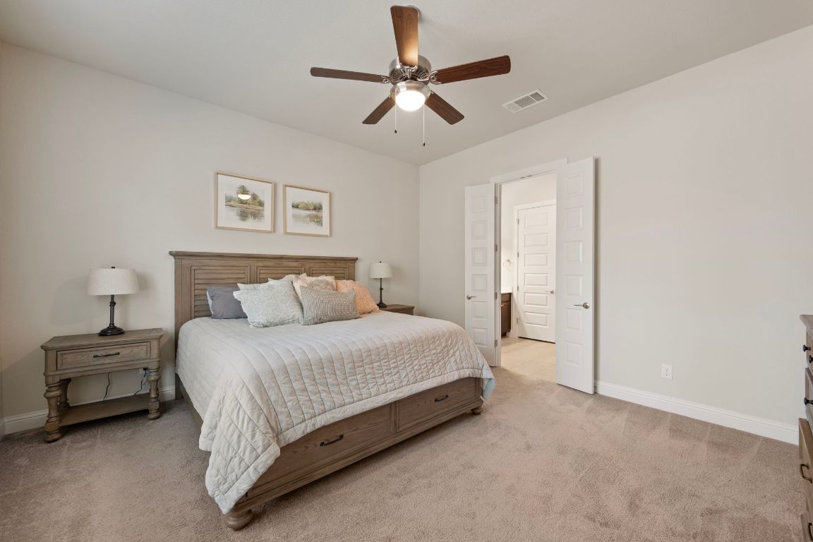 1601 Highland Ridge Road Georgetown, TX 78628 - Photo 14 of 37 a spacious bedroom with a bed and a ceiling fan