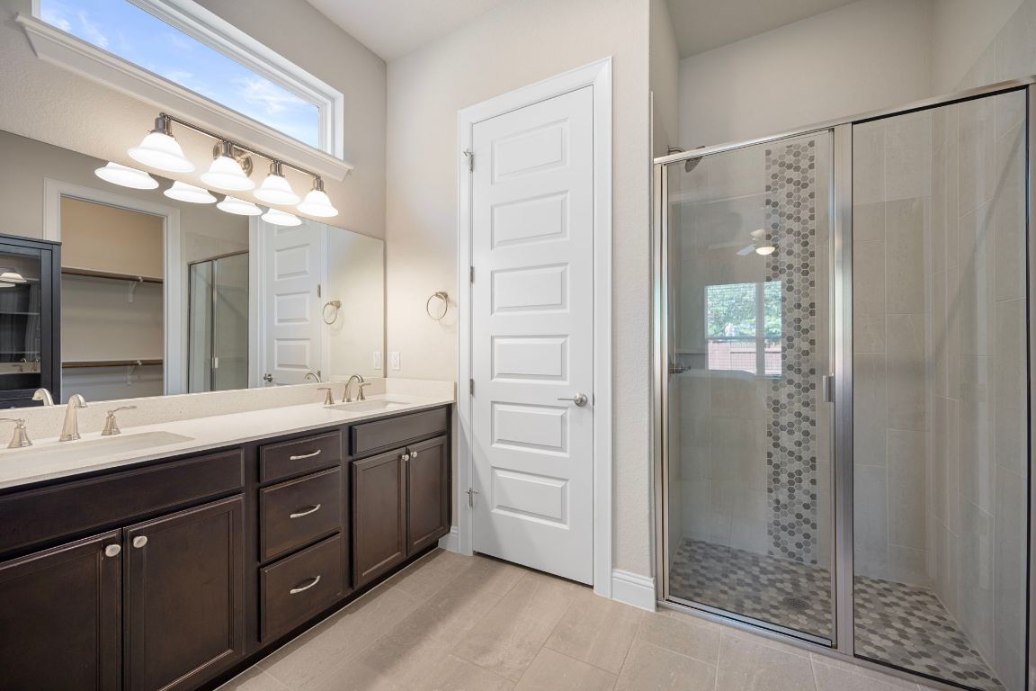 1601 Highland Ridge Road Georgetown, TX 78628 - Photo 16 of 37 a spacious bathroom with a double vanity sink a large mirror and shower