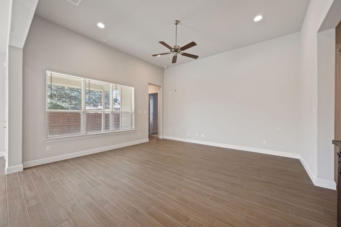 1601 Highland Ridge Road Georgetown, TX 78628 - Photo 6 of 37 an empty room with wooden floor ceiling fan and windows