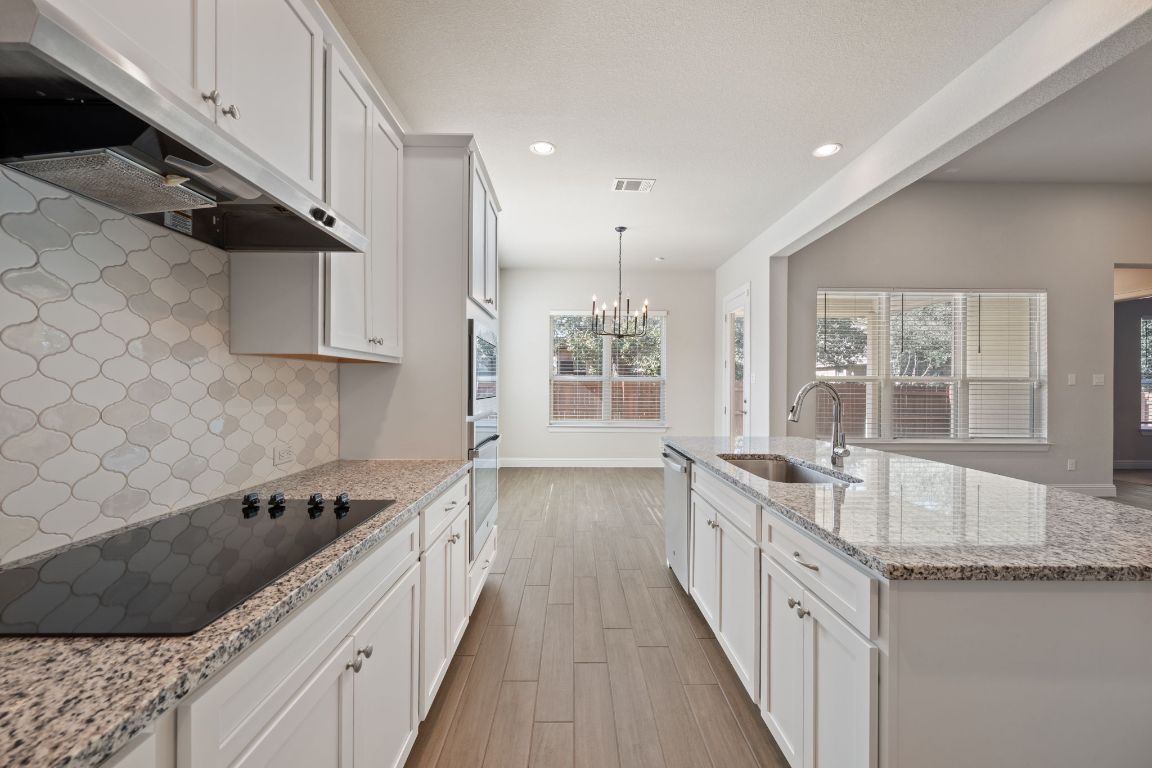 1601 Highland Ridge Road Georgetown, TX 78628 - Photo 10 of 37 a large kitchen with granite countertop a sink and cabinets