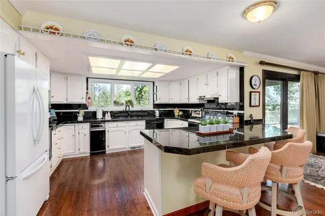 a kitchen with granite countertop a sink stainless steel appliances and window
