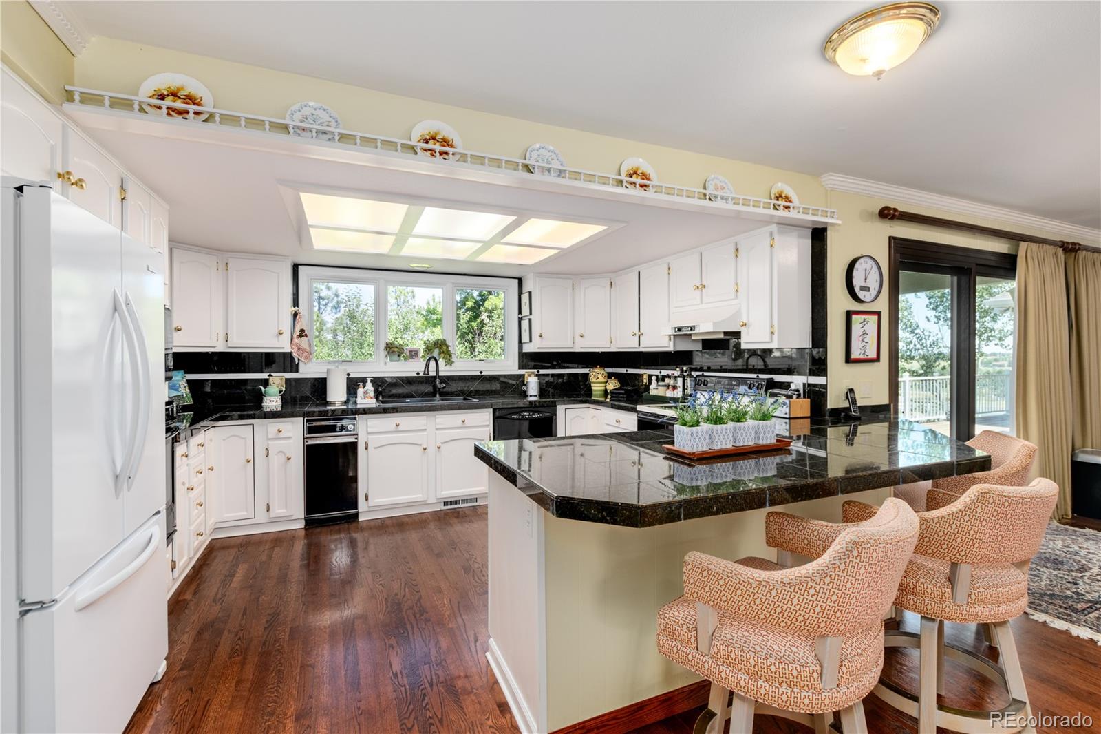 7846 North Village Road Parker, CO 80134 - Photo 17 of 50 a kitchen with a dining table chairs and refrigerator