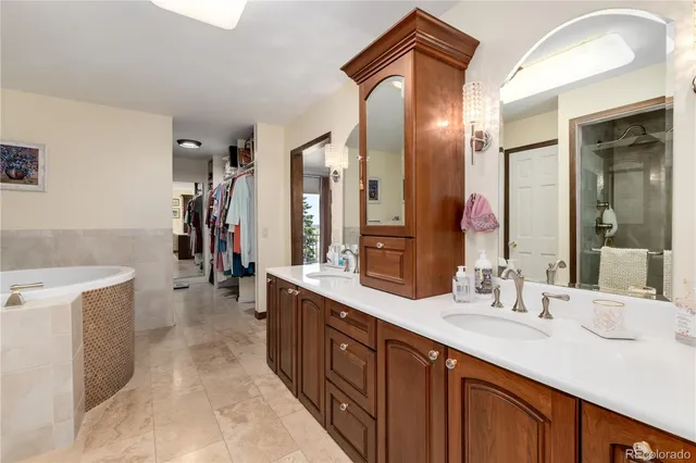 a spacious bathroom with a tub sink and mirror