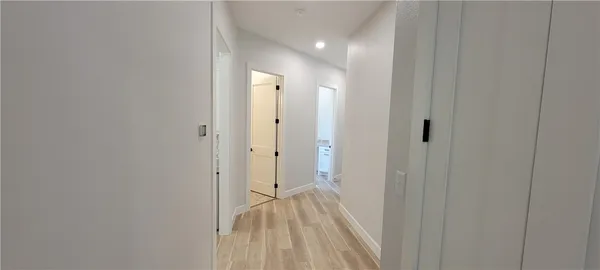 a view of a hallway with wooden floor