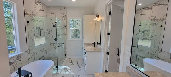 a bathroom with a sink shower and a mirror