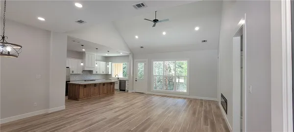 a large kitchen with stainless steel appliances a large counter top a sink and a window