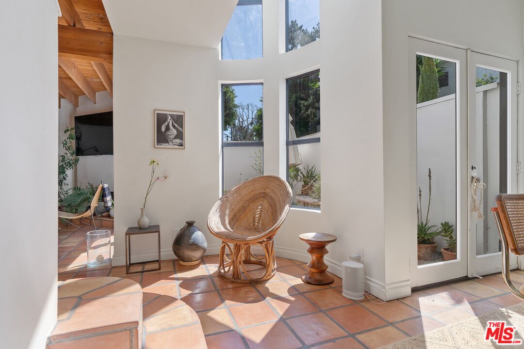 29221 Heathercliff Road, Unit 2 Malibu, CA 90265 - Photo 5 of 19 a living room with couches a mirror and a table with wooden floor