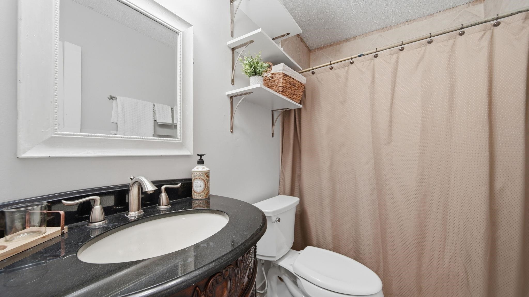 4182 Luther Road Memphis, TN 38135 - Photo 27 of 40 a bathroom with a granite countertop bathtub sink vanity mirror and toilet
