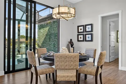a dining room with furniture a chandelier and wooden floor
