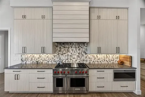 a kitchen with white cabinets and stainless steel appliances