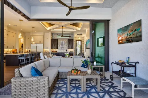 a front view of a house with swimming pool lawn chairs and a barbeque