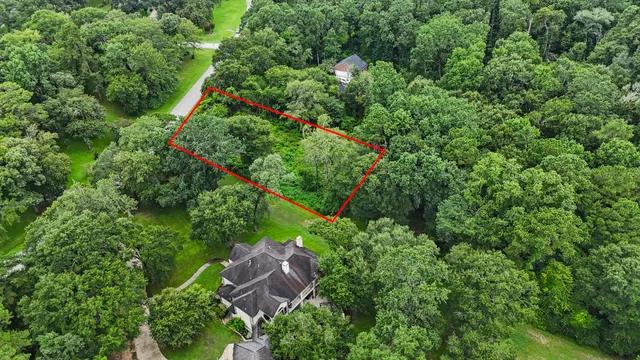 an aerial view of residential house with outdoor space and trees all around