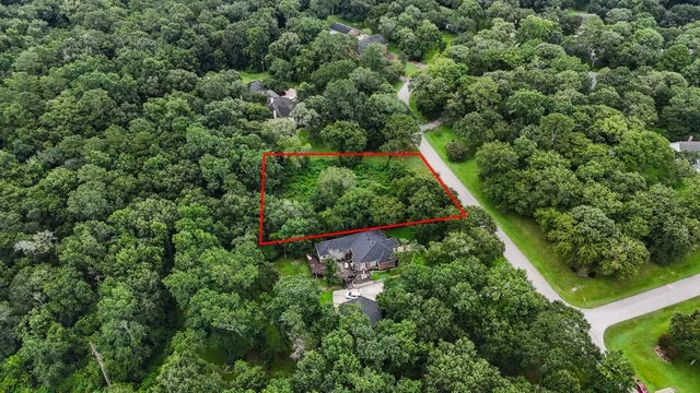 an aerial view of residential houses with outdoor space and trees