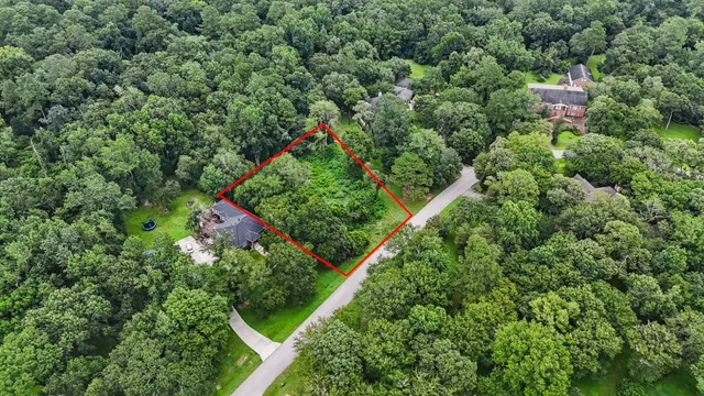 an aerial view of residential house with outdoor space and trees all around