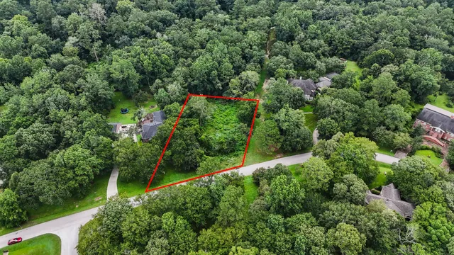 an aerial view of residential house with outdoor space and trees all around